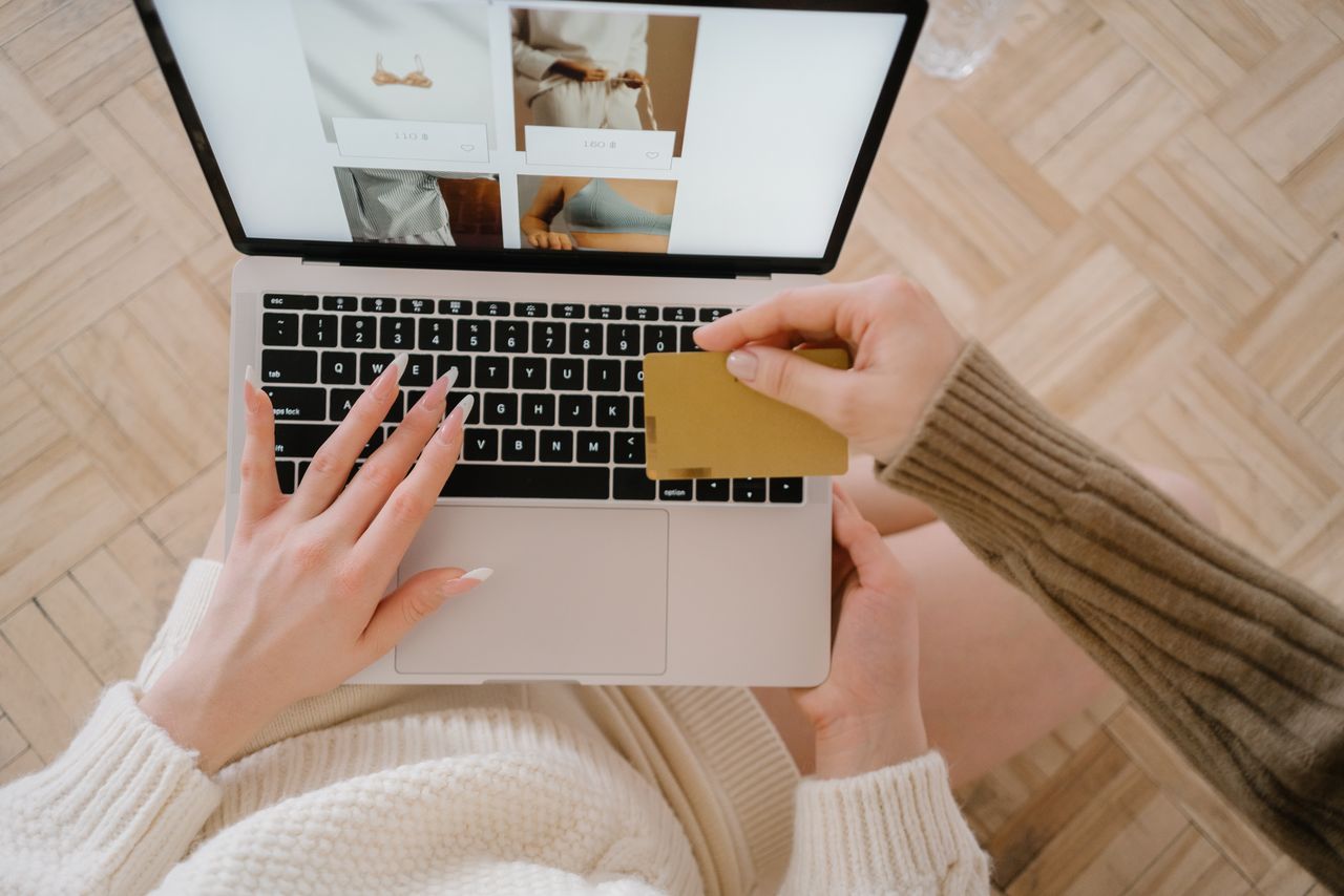 services-01 Osoba kupuje online koristeći laptop i kreditnu karticu, ističući praktičnost e-trgovine.